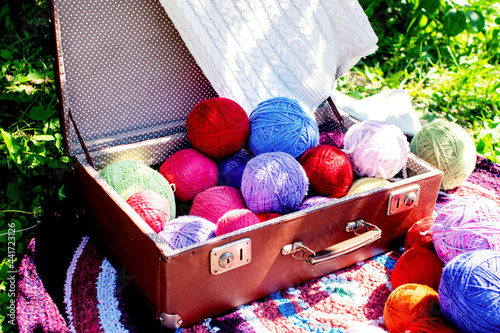 Balls of colored multicolored yarn in an old suitcase. Knitting wool yarn.
