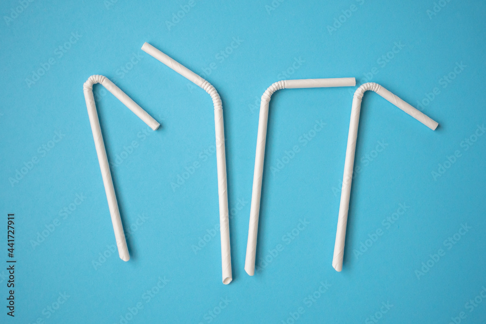 Obraz premium Biodegradable eco friendly white paper drinking straw on blue background