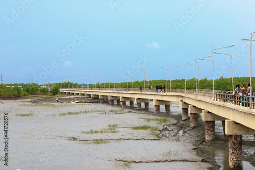 Pier or jetty, footpath promenade, and sea at sunrise. Beautiful view of pier or jetty for background. Empty Jetty on Karnaphuli River, Bangladesh at Sunset for wallpaper.