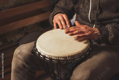 Hands of a drummer playing the ethnic percussion musical instrument djembe