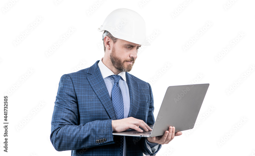 businessman man in suit and safety helmet wotking on laptop online isolated on white, work online. businessman man in suit and safety helmet wotking on laptop online isolated on white, work online.