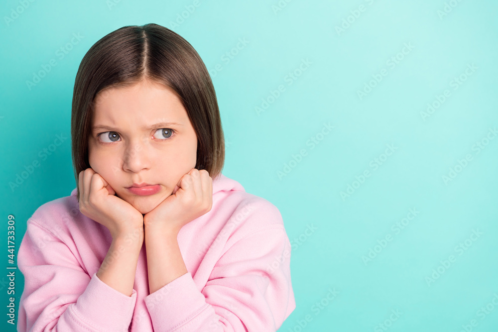 Photo of short hairdo sad little girl hands cheeks look empty space wear pink sportswear isolated on teal color background Photo of short hairdo sad little girl hands cheeks look empty space wear pink sportswear isolated on teal color background