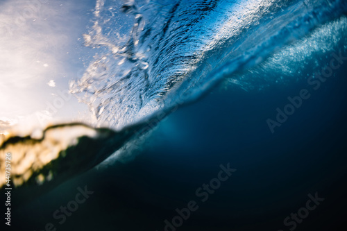 Crashing surfing wave in sea with warm tones at sunrise or sunset
