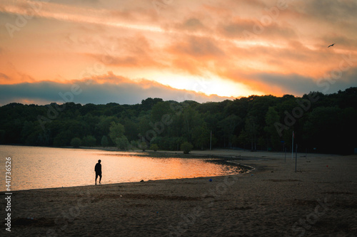 sunset silhouette of a person walking on the beach