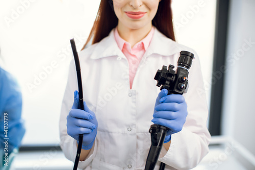 Gastrointestinal fiberoptic endoscopy concept. Cropped close up shot of female doctor holding modern endoscope device before gastroscopy examination photo