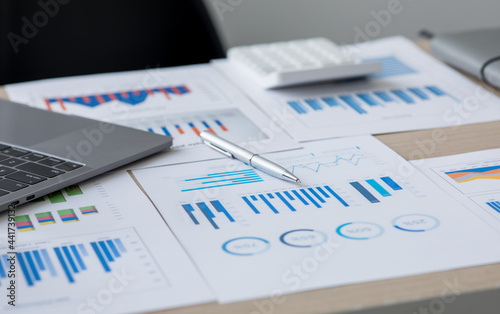 Financial accounting concept with graphs and charts Preparing report.Business reports and pile of documents on gray reflection background. 