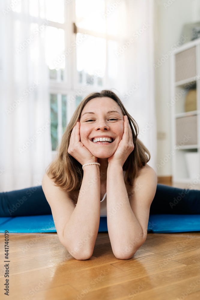 Content woman sitting in Split yoga pose and looking at camera Content woman sitting in Split yoga pose and looking at camera