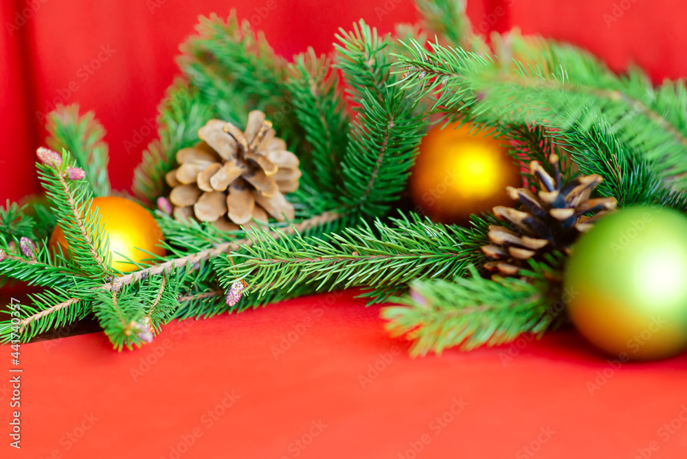 Christmas background, green pine branches with cones and Christmas balls on a red background. Creative composition with border and copy space, top view. New year, holiday, christmas Christmas background, green pine branches with cones and Christmas balls on a red background. Creative composition with border and copy space, top view. New year, holiday, christmas