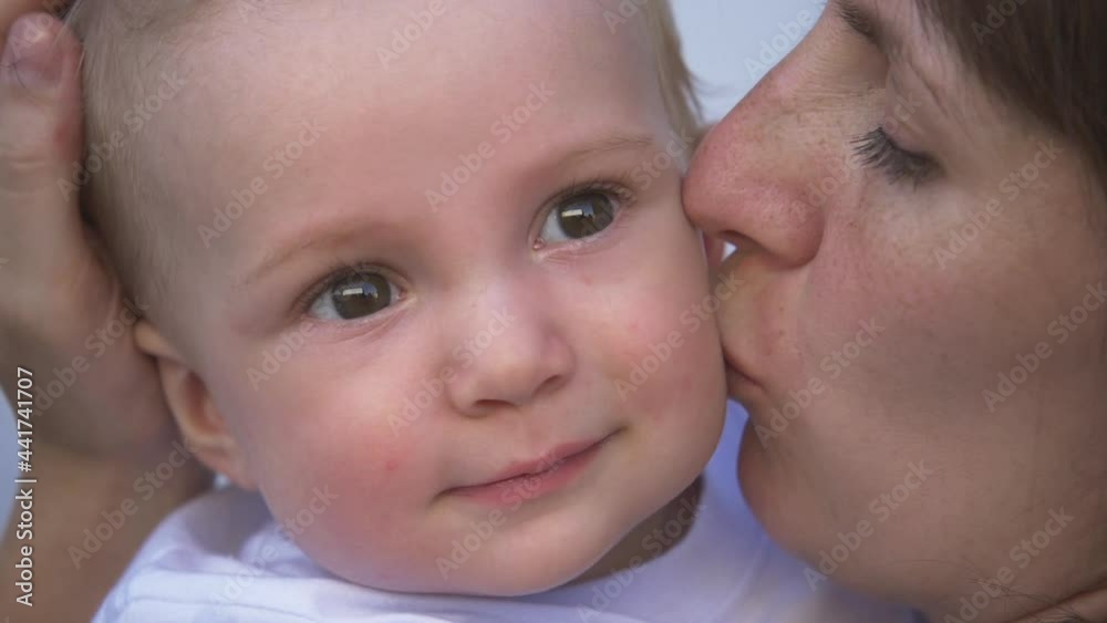 loving caring mother holds a happy baby, hugs, kisses a small child. Happy affectionate mother hugs her boy son, takes care of the child at home. Mother kissing her baby loving caring mother holds a happy baby, hugs, kisses a small child. Happy affectionate mother hugs her boy son, takes care of the child at home. Mother kissing her baby