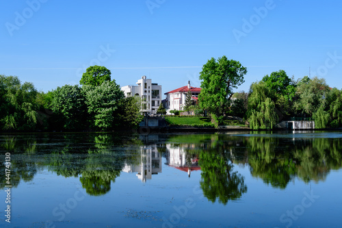 Landscape with old green trees near Mogosoaia lake and park, a weekend attraction close to Bucharest, Romania, in a sunny spring day.