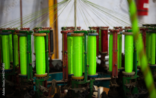 Rope making machine in a factory, multiple spindles with colorful, smaller rope being combined to make larger, thicker, stronger rope. © Yojak Vasa