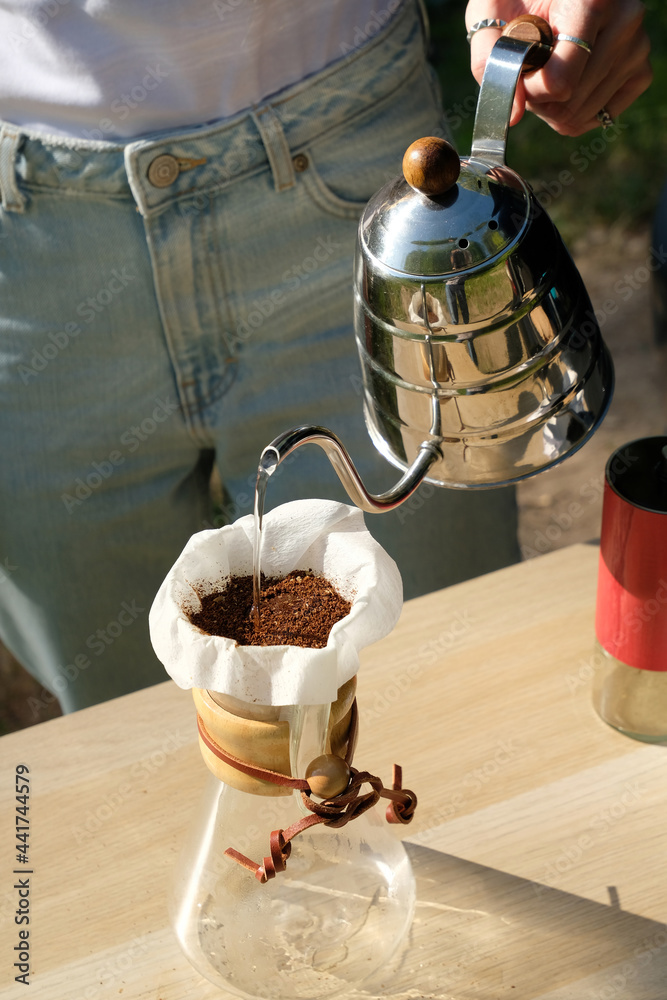 Manual drip coffee brewing. Water pours into dripper from gooseneck
