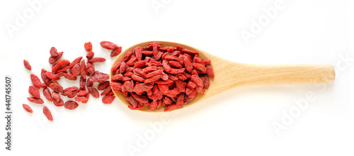 Dry organic goji berry seed pile in wooden spoon on white background