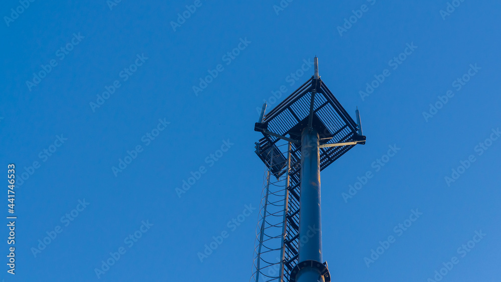 A tower for amplifying the cellular signal against the blue sky A tower for amplifying the cellular signal against the blue sky