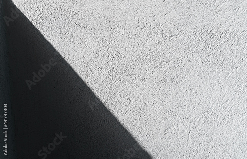 Biała ściana z fakturą oraz światło cieniami, jasne tło i tekstura.
