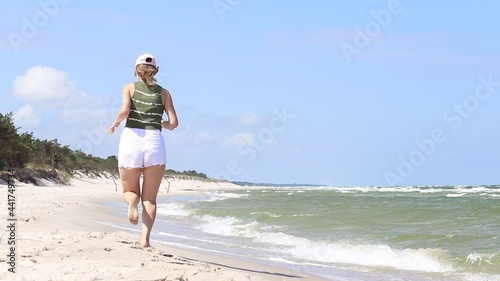 Young girl walking on the beach photo