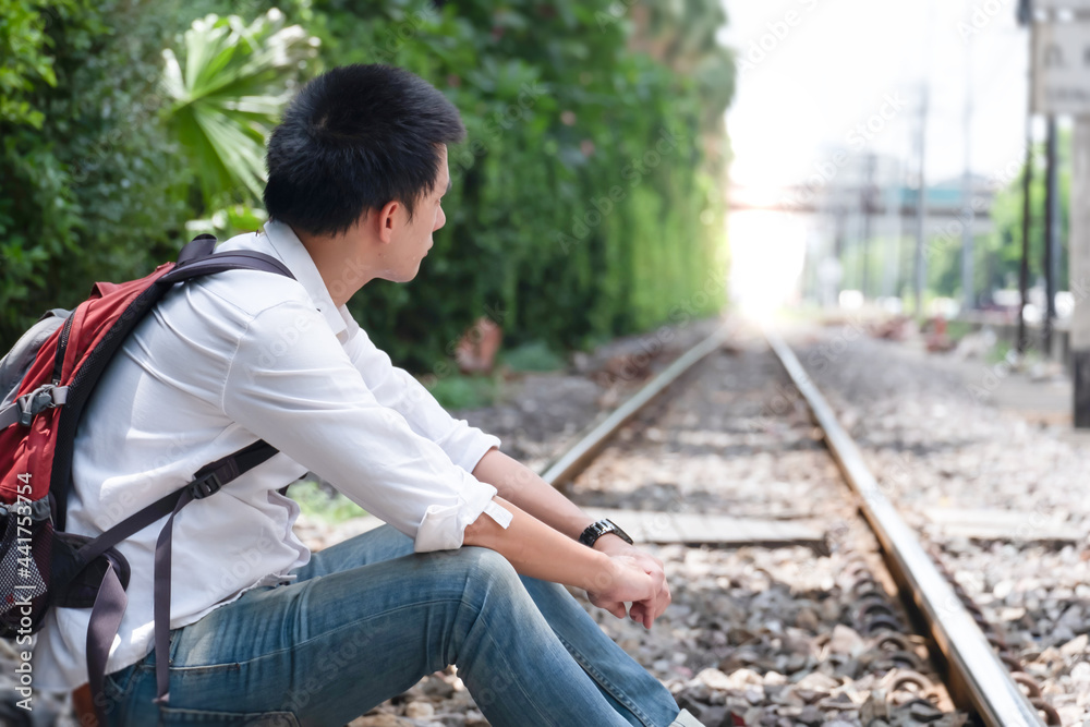Obraz premium portrait of asian man, Young traveler with backpack in the railway, the train station with a traveler, Travel concept 