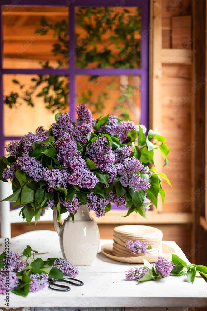 Bouquet of lilacs in a vintage basket. Beautiful violet Lilac flower still life Easter border design on wooden table.