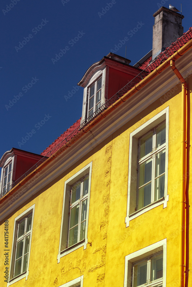 Facade of the old bright yellow arcitecture building with red foof in the center of Old Town. Tourism Facade of the old bright yellow arcitecture building with red foof in the center of Old Town. Tourism