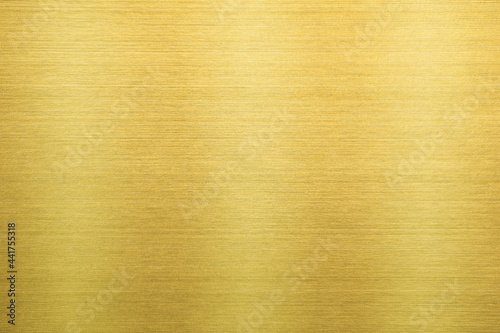 Shiny gold polished metal background texture of brushed stainless steel plate with the reflection of light.