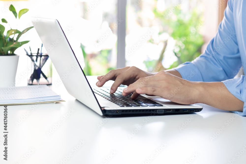 The hand of the office manager uses a laptop keyboard while working. The hand of the office manager uses a laptop keyboard while working.