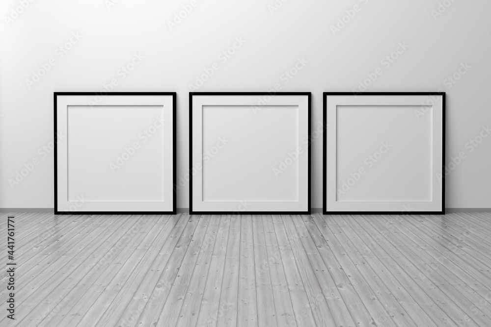 Mockup template of three square frame with thin black frame border standing next to wall on wooden floor Mockup template of three square frame with thin black frame border standing next to wall on wooden floor