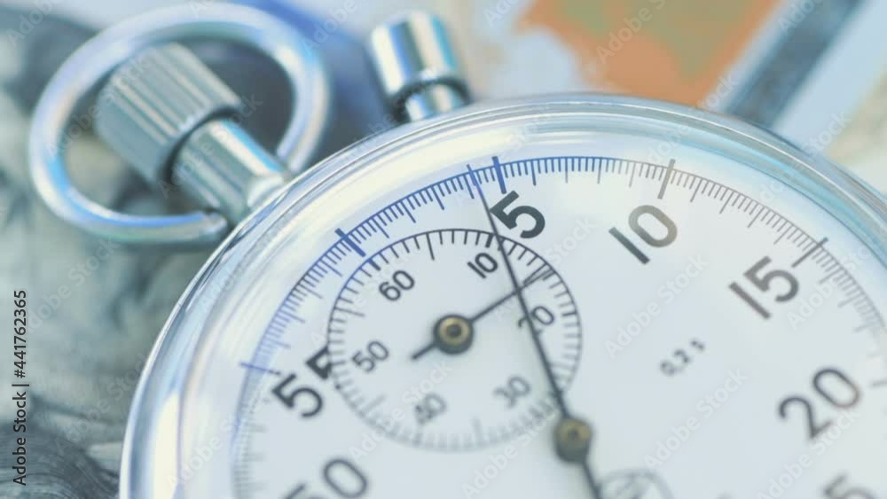 The second hand runs across stopwatch dial over the dollar banknotes. Financial money concept . The second hand runs across stopwatch dial over the dollar banknotes. Financial money concept .