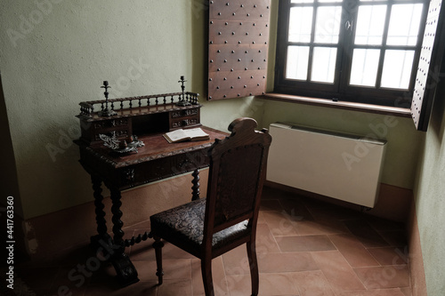 Schilderij op canvas Medieval fortress Cabinet with writing desk with a book and wooden brown chair - interior furniture