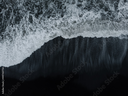 Abstract nature background. Aerial drone view of black sand beach and ocean waves in South Iceland © Ivan Kurmyshov