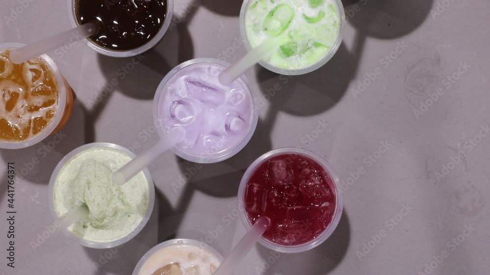Male hand picking up delicious milk tea beverage with crushed ice. Male hand picking up delicious milk tea beverage with crushed ice.