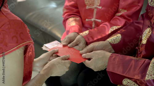 Mature adult daugther kid give red envelop to older parent in Chinese New Year