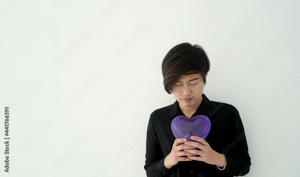 Sad lonely Asian woman holding hurt purple heart balloon Sad lonely Asian woman holding hurt purple heart balloon