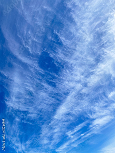 Delicate cirrus clouds in the blue sky in sunny day