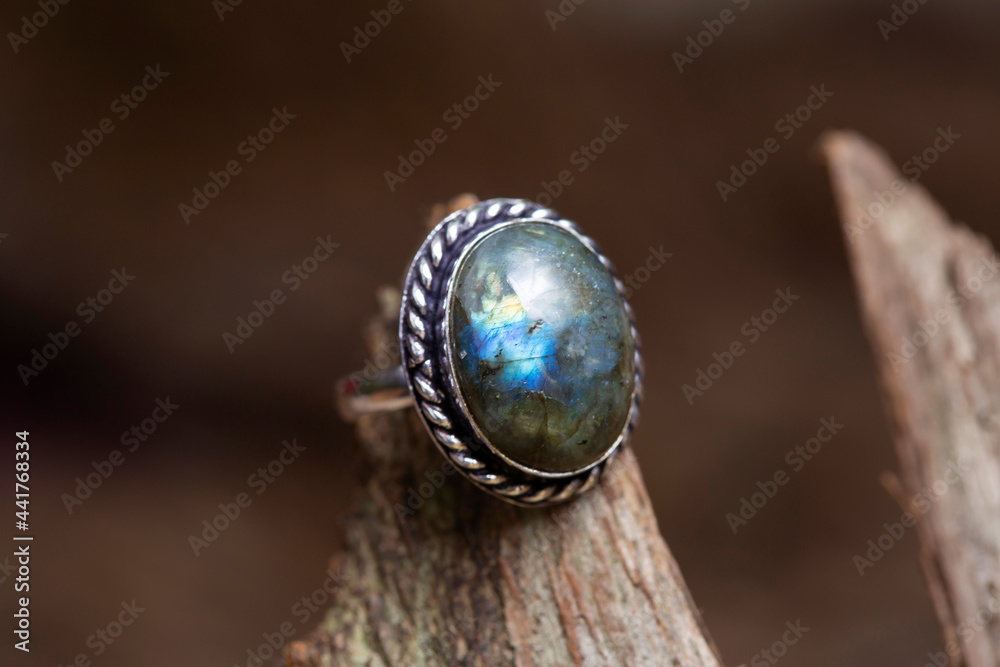 Brass metal labradorite mineral stone ring on natural background Brass metal labradorite mineral stone ring on natural background
