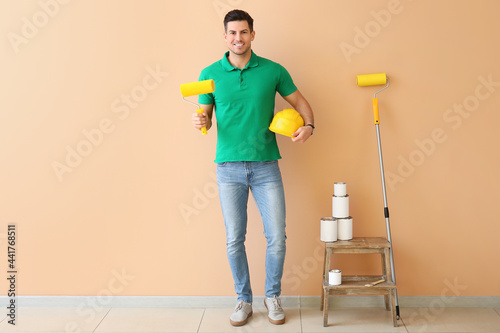 Young man with paint roller...