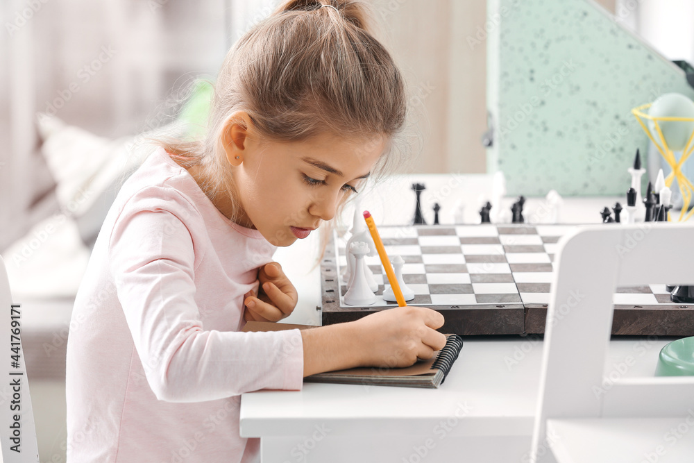 Cute little girl playing chess at home Cute little girl playing chess at home