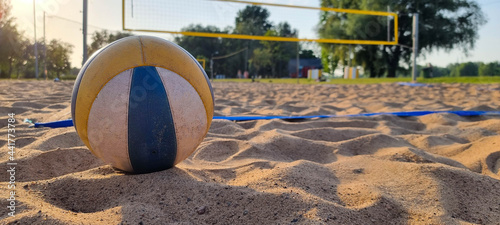 Beach volleyball court with a volleyball ball placed in the sand. photo