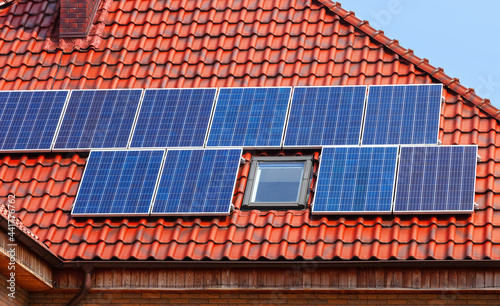 Modern solar panels on a red tiled roof.