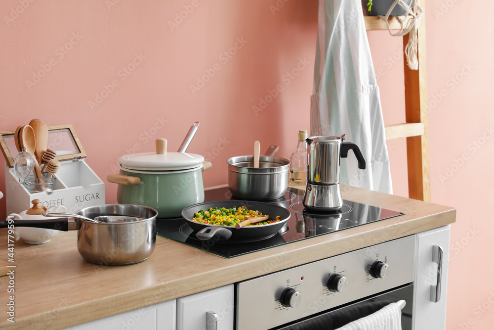 Modern electric stove and utensils in kitchen Modern electric stove and utensils in kitchen