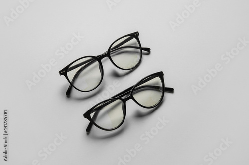 Different stylish eyeglasses on light background