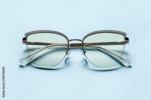 Stylish eyeglasses on color background, closeup