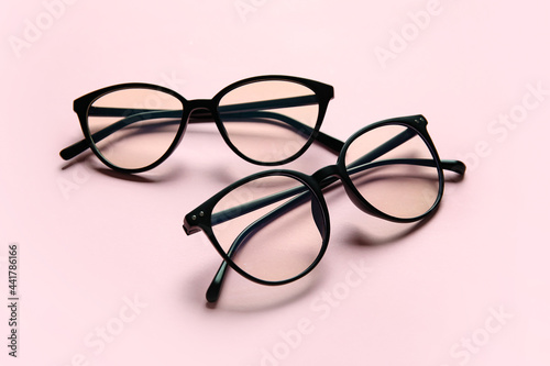 Different stylish eyeglasses on color background