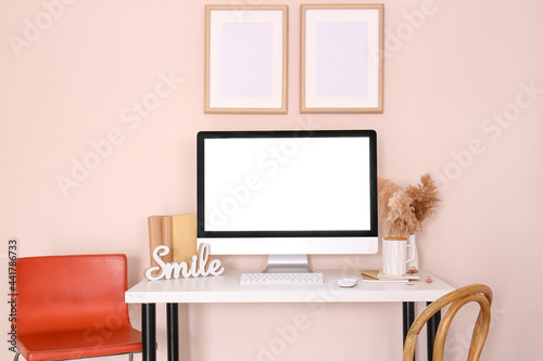 Stylish workplace with modern computer on table near color wall © Pixel-Shot