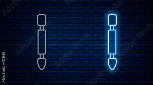 Glowing neon line Cuticle pusher icon isolated on brick wall background. Tool for manicure. Vector