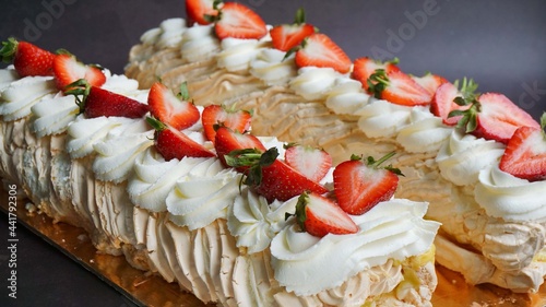 food dessert meringue roll with strawberries and butter cream