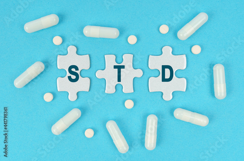 On a blue background, there are pills and puzzles with the inscription - STD