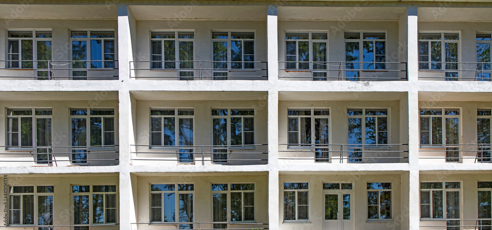 fragment of a facade of a building with balcony with table and chair