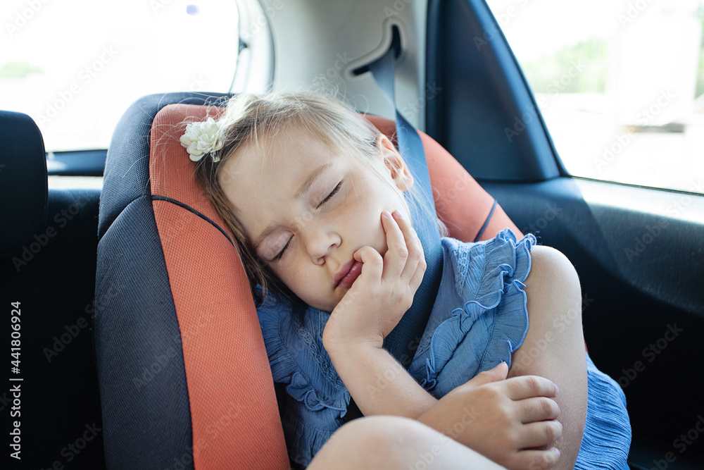 Little girl sleeping while sitting in car