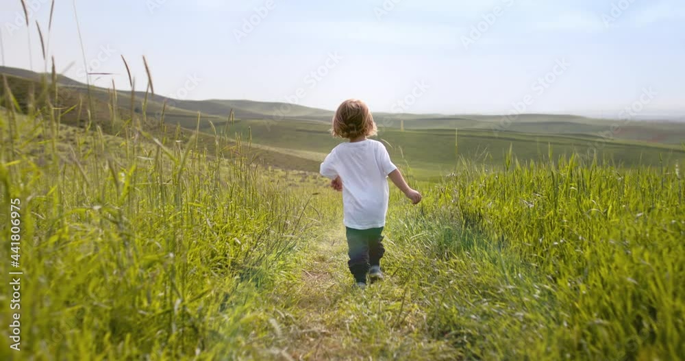Baby boy running in grass in hill. Little cute kid enjoying time in nature, having fun in field - freedom, adventure, discovery, childhood dream 4k footage Baby boy running in grass in hill. Little cute kid enjoying time in nature, having fun in field - freedom, adventure, discovery, childhood dream 4k footage