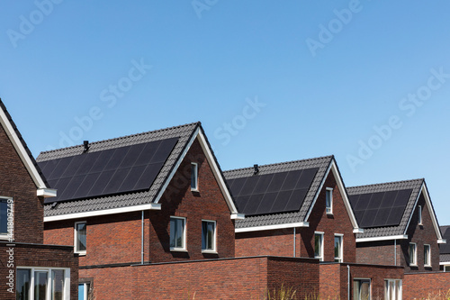 Solar panels on the roof of new built houses in The Netherlands collecting green energy from the sun in a modern and sustainable way